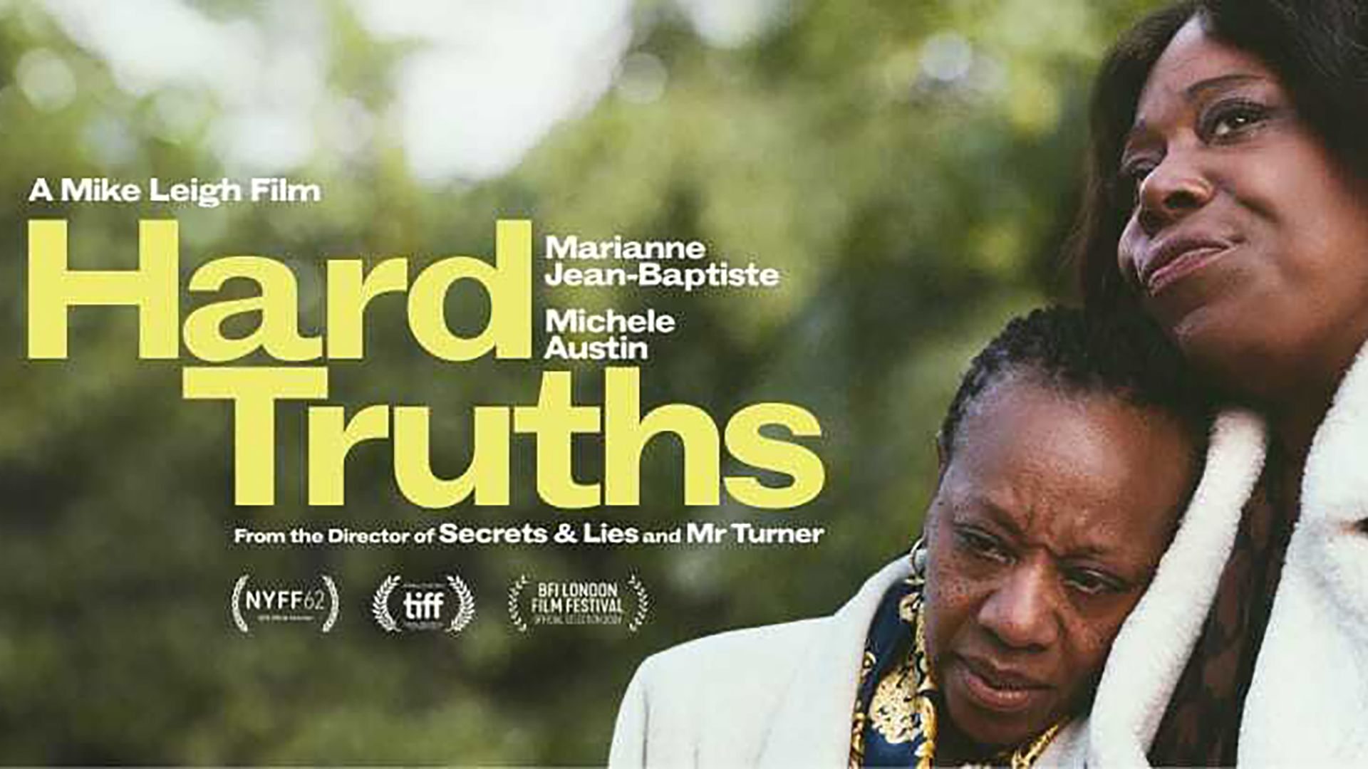 Två kvinnor står och håller om varandra ute i en park. Till vänster står det filmens titel "Hard Truths"