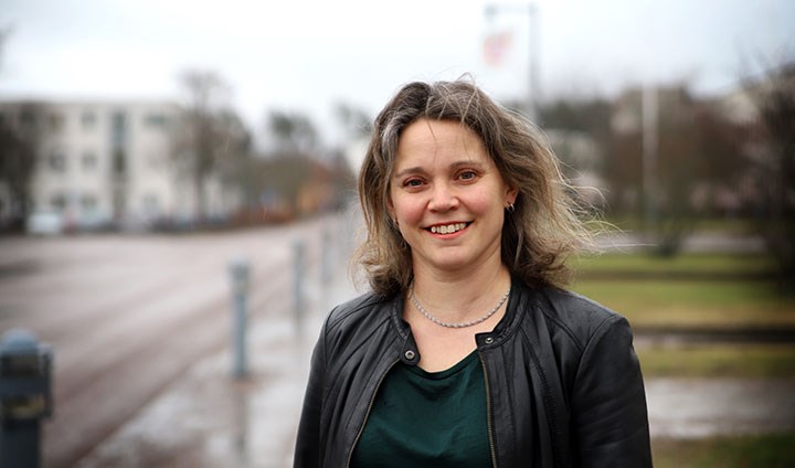 En kvinna i halvlångt hår, rufsigt i vinden, och svart jacka.