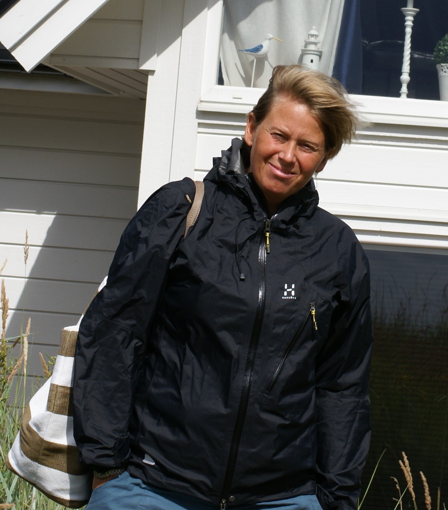 Hillevi Karlsson står i överdragskläder. Vinden blåser i hennes korta hår.